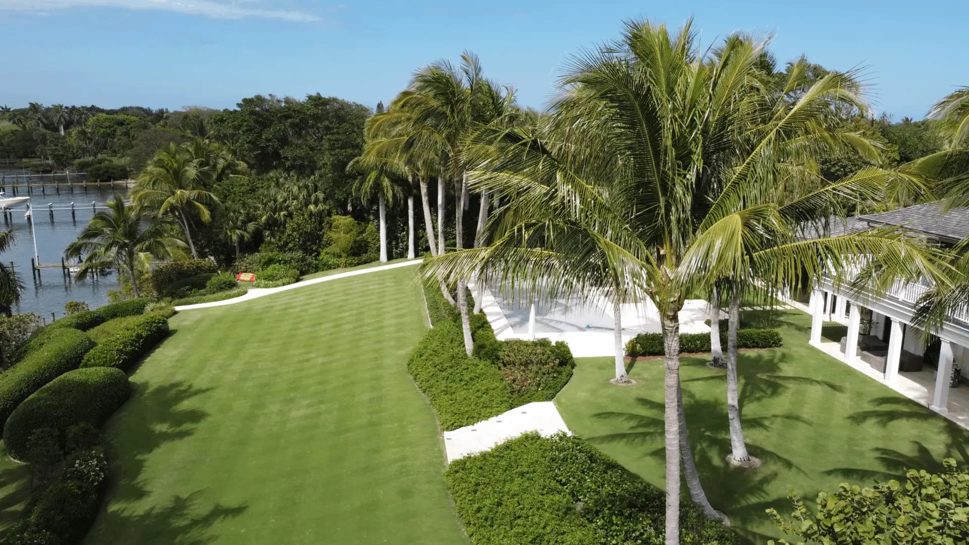Luxury waterfront estate landscaping with manicured lawns and palm trees in Palm Beach County, Florida
